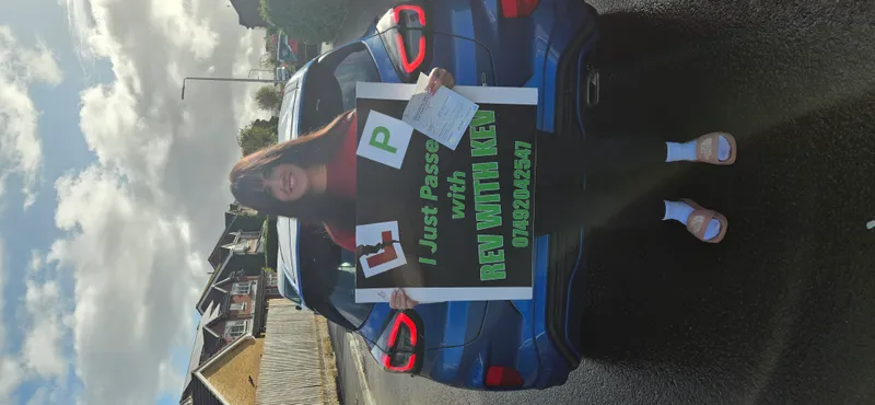 Learner driver celebrating passing automatic driving test with Rev with Kev
